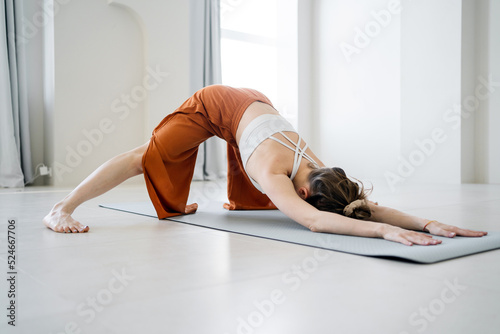 Young woman doing yoga workout pose asana, harmony and body balance uses mat