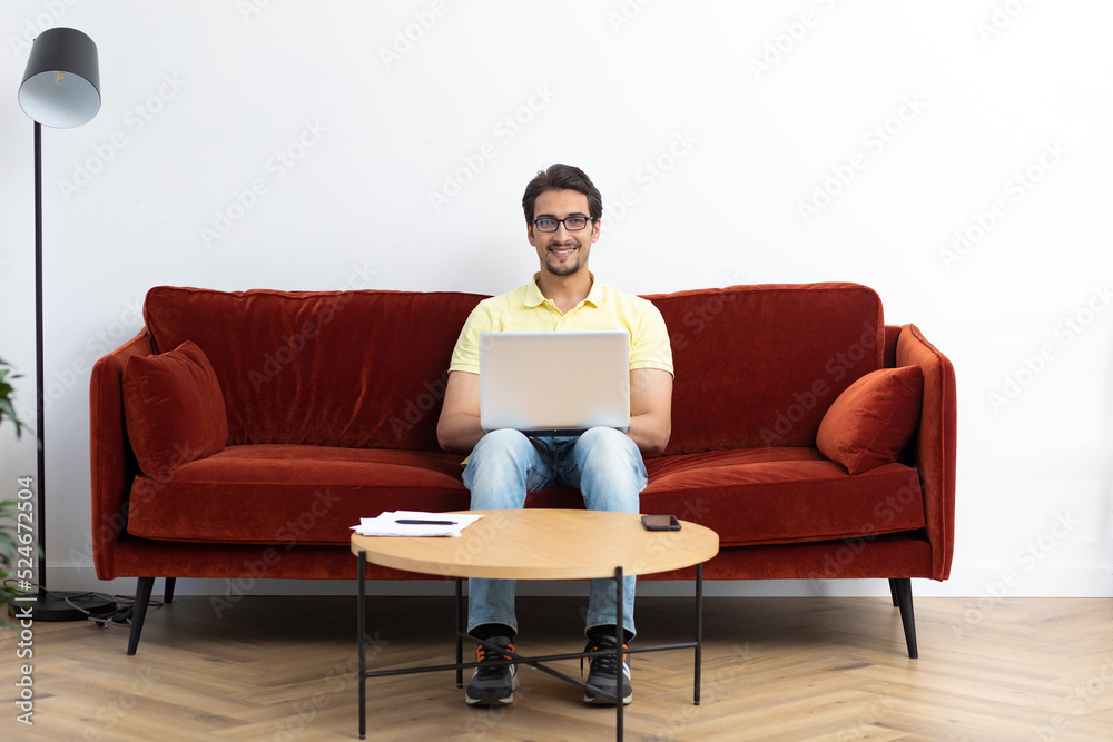 Young businessman working on laptop at home. Distant work concept Young businessman working on laptop at home. Distant work concept