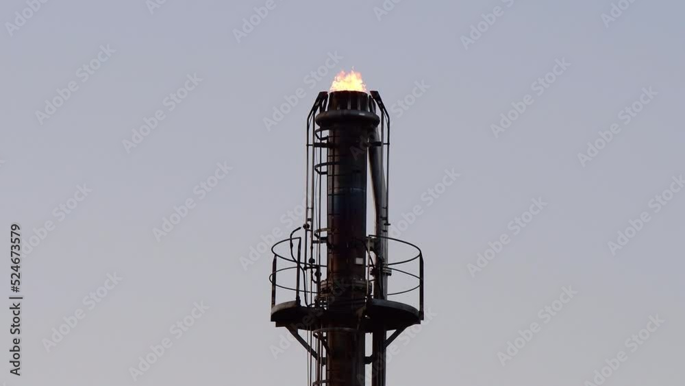 Oil refinery plant, fire coming out of a tower Oil refinery plant, fire coming out of a tower