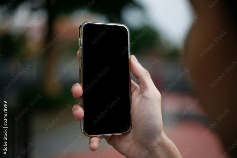 person holding smartphone. close up hand holding smartphone using and showing a blank phone screen person holding smartphone. close up hand holding smartphone using and showing a blank phone screen
