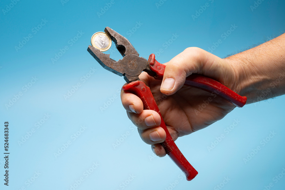Fototapeta premium a 1 euro coin crushed with pliers. the concept of financial pressure on the currency