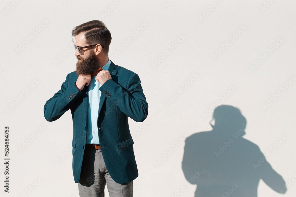 Stylish man with beard wearing a jacket, shirt and bow tie