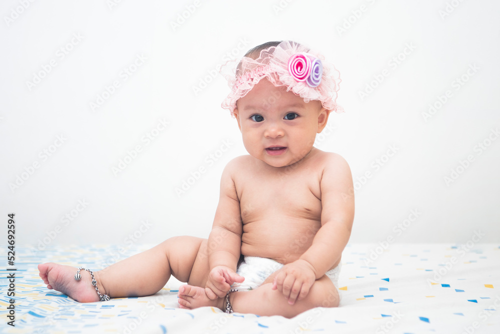 Full body portrait of Asian baby girl sitting on the bed smiling Full body portrait of Asian baby girl sitting on the bed smiling