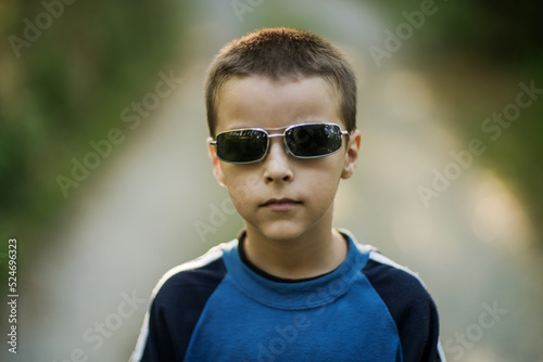 born to be wild, the sympathetic boy sits leaning on an old motorcycle, hot summer day with the warm colors of summer
