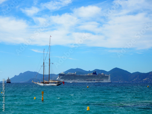 Cannes, France - October 2019: Cruise Liner and sailboat moored just off the Promenade de la Croisette at Cannes, Cote d'Azur, France