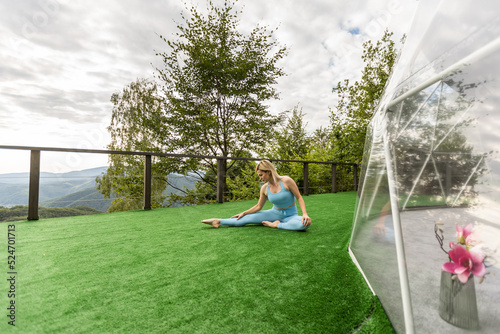 a woman is doing exercises on the terrace of a transparent bubble dome photo