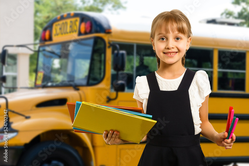 Smiling active excellent best student schoolgirl holding books and going to school wearing bag