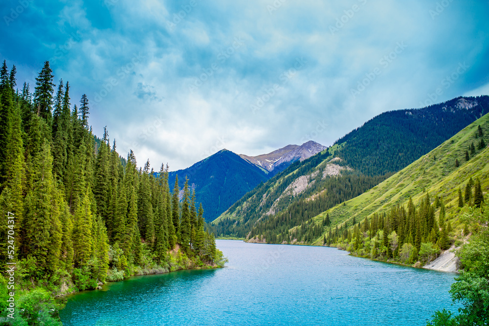 Lake Kaindy sunken forest in Kazakhstan. Beautiful mountain nature landscape. Blue lake Kolsai top view. Panoramic view of the nature reserve. Lake Kaindy sunken forest in Kazakhstan. Beautiful mountain nature landscape. Blue lake Kolsai top view. Panoramic view of the nature reserve.