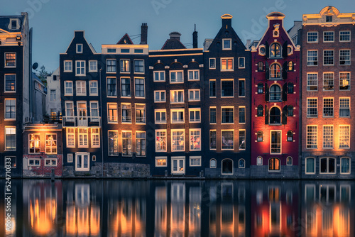 Amsterdam reflections. A view on the buildings by the canal from Damrak avenue in the center of Amsterdam, Holland.