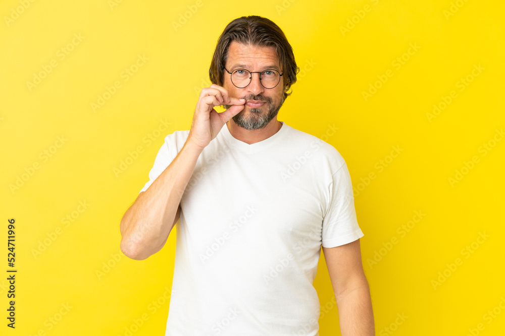Senior dutch man isolated on yellow background showing a sign of silence gesture Senior dutch man isolated on yellow background showing a sign of silence gesture