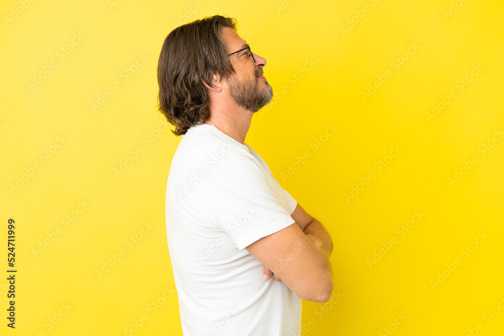 Senior dutch man isolated on yellow background in lateral position Senior dutch man isolated on yellow background in lateral position