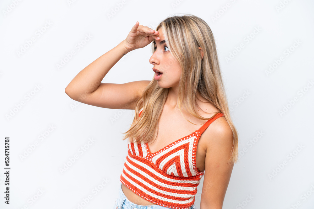 Young caucasian woman isolated on white background with surprise expression while looking side