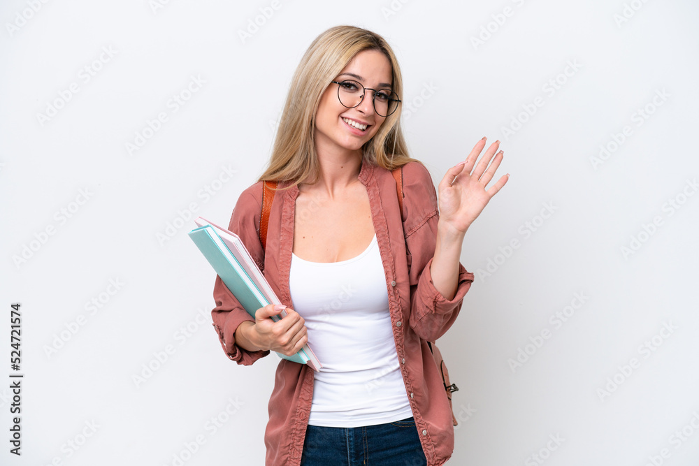 Pretty student blonde woman isolated on white background saluting with hand with happy expression Pretty student blonde woman isolated on white background saluting with hand with happy expression