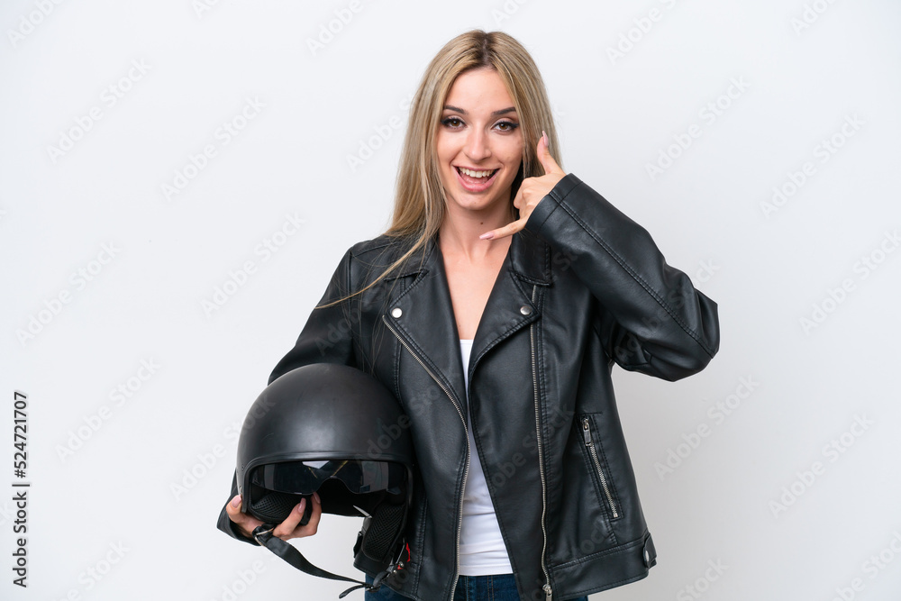 Pretty blonde woman with a motorcycle helmet isolated on white background making phone gesture. Call me back sign Pretty blonde woman with a motorcycle helmet isolated on white background making phone gesture. Call me back sign