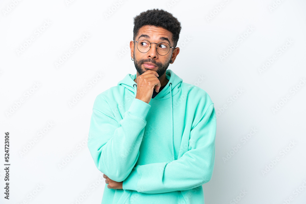 Young Brazilian man isolated on white background having doubts and thinking Young Brazilian man isolated on white background having doubts and thinking
