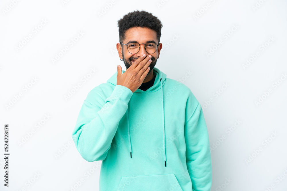 Young Brazilian man isolated on white background happy and smiling covering mouth with hand
