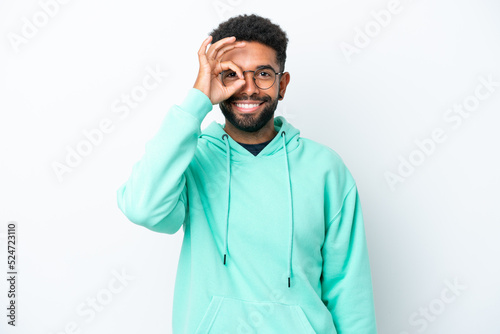 Young Brazilian man isolated on white background showing ok sign with fingers