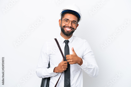Young architect Brazilian man with helmet and holding blueprints isolated on white background giving a thumbs up gesture
