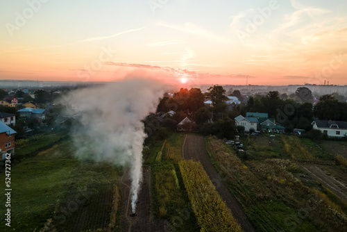 Aerial view of agricultural waste bonfires from dry grass and straw stubble burning with thick smoke polluting air during dry season on farmlands