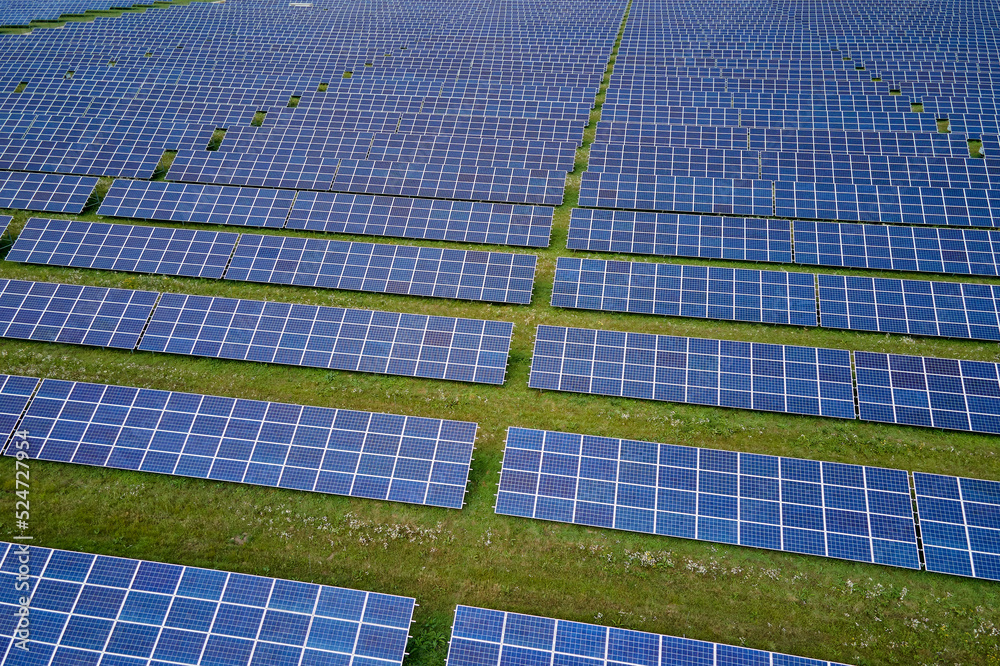 Aerial view of large sustainable electrical power plant with rows of solar photovoltaic panels for producing clean electric energy. Concept of renewable electricity with zero emission Aerial view of large sustainable electrical power plant with rows of solar photovoltaic panels for producing clean electric energy. Concept of renewable electricity with zero emission