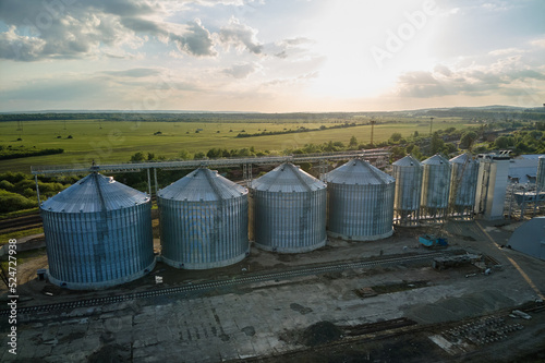 Aerial view of industrial ventilated silos for long term storage of grain and oilseed. Metal elevator for wheat drying in agricultural zone