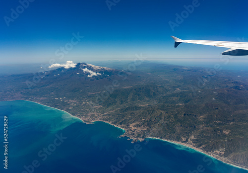 Urlaub und Touristenmagnet auf Sizilien: der Vulkan Ätna von oben aus dem Flugzeug betrachtet mit der Hafenstadt Catania photo