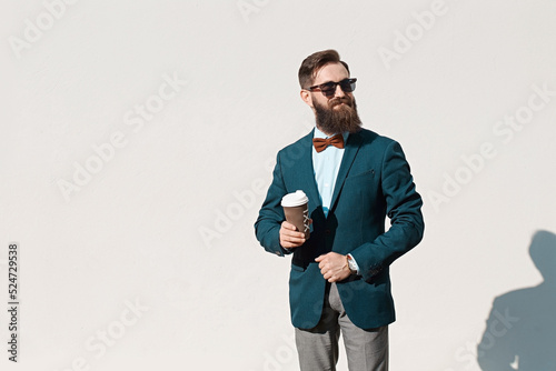 Stylish man with beard wearing a jacket, shirt and bow tie