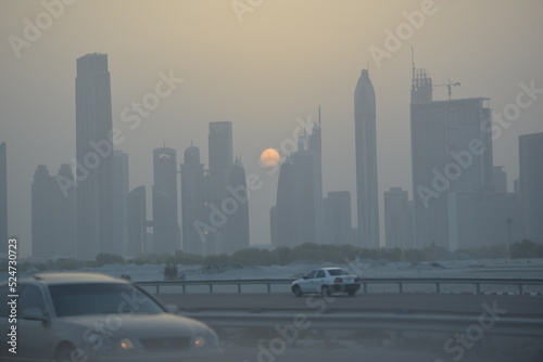 Evening sunset in Dubai city view skyscrapers and setting sun