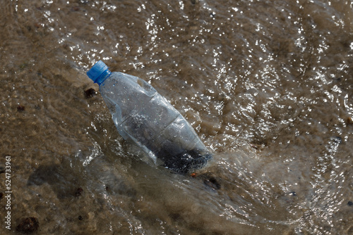 Plastic water PET bottle on a beach.