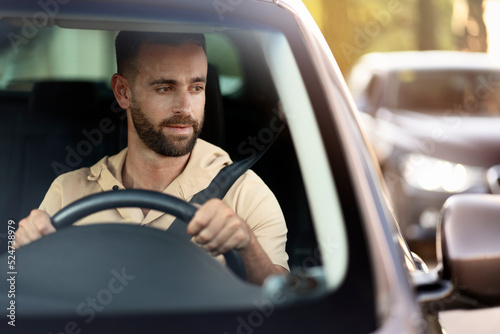 Serious handsome hispanic business man driving a car, copy space. Sad latin driver stuck in traffic