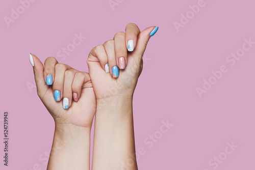 Geometry nail art design in white and blue colors on pink background