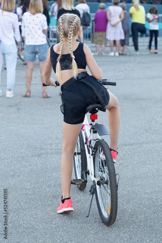 Fototapeta Naklejka Na Ścianę i Meble -  A woman on a bicycle on a city street. A bike ride.