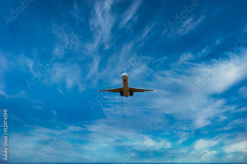 Airplane flying about to land. Airplane seen from below. Blue sky