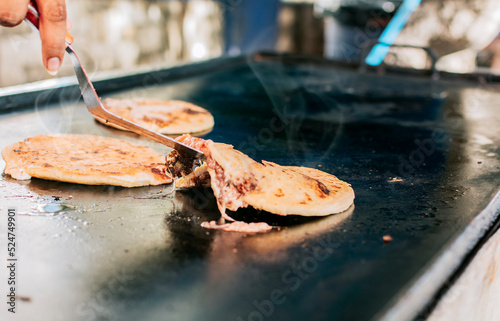 Traditional grilled cheese pupusas, Close up of traditional handmade pupusas on grill. Traditional Nicaraguan Pupusas with melted cheese on grill photo