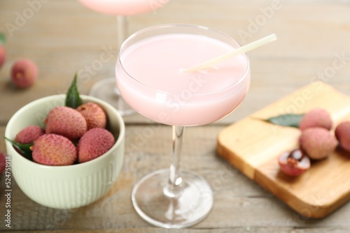 Delicious lychee cocktail and fresh fruits on wooden table, closeup