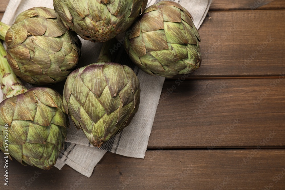 Fresh raw artichokes on wooden table, flat lay. Space for text Fresh raw artichokes on wooden table, flat lay. Space for text