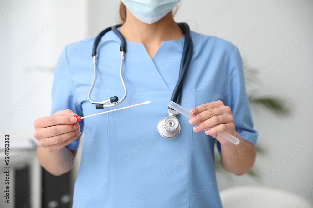Doctor holding buccal cotton swab and tube for DNA test in clinic, closeup Doctor holding buccal cotton swab and tube for DNA test in clinic, closeup