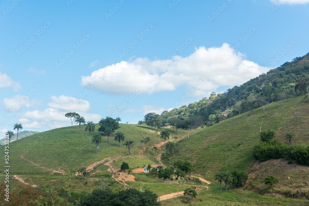 Landscape of a valley and mountains with grass and blue sky in the city of Macuco, State of Rio de Janeiro, Brazil.