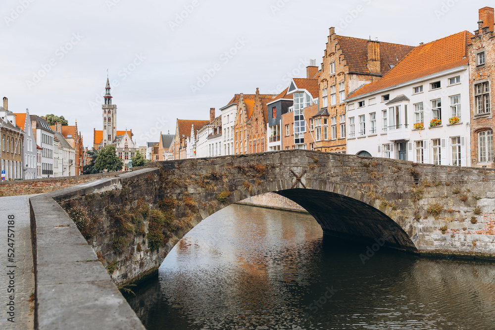 Scenic city view of Bruges canal with beautiful medieval colored houses, bridge in the morning hour, Belgium