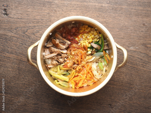 bowl of Bibimbap, Korean mixed rice with assorted vegetables and meat, on wooden background