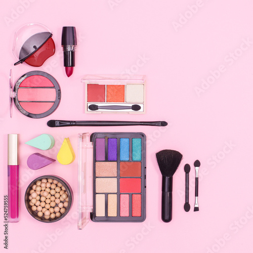 Colorful make up products layout on pastel pink background. Flat lay