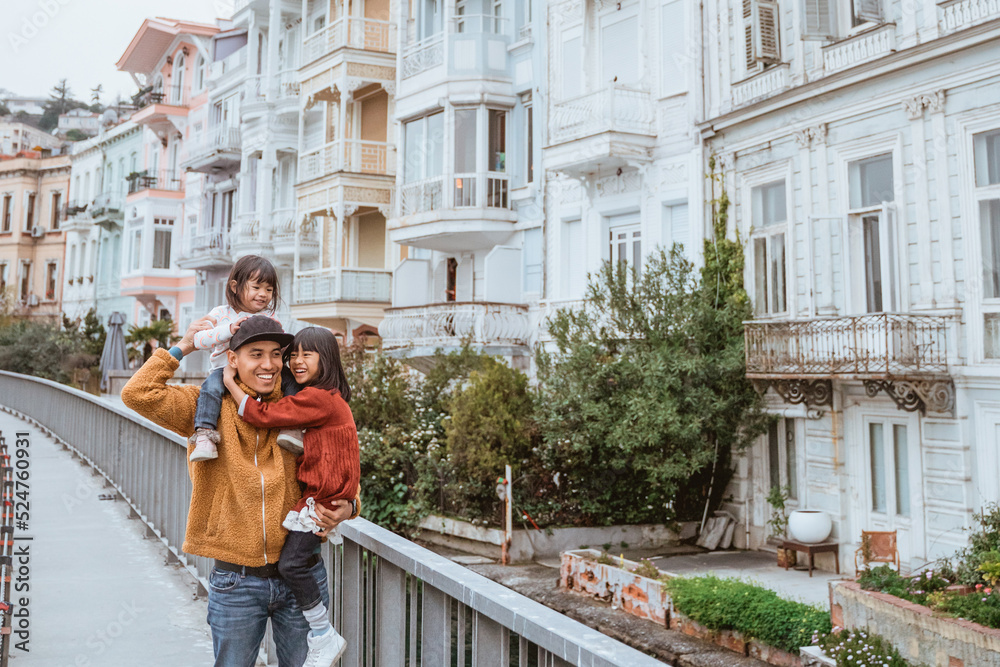 Fototapeta premium father carrying his daughter on a shoulder while exploring bebek arnavutkoy area in istanbul turkey