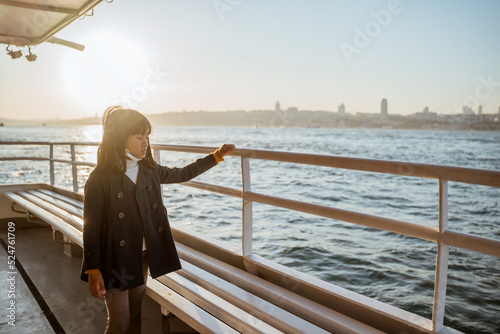 Canvastavla young girl in ferry boat leaning against the railing looking at the sea of bosph