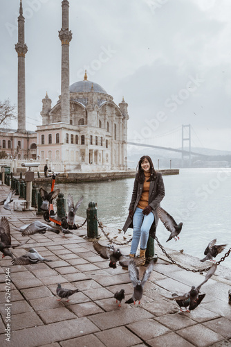 Photography beautiful woman sitting near bosphorus with ortakoy mosque at the background