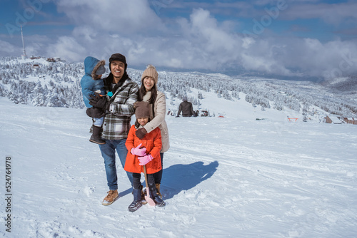 family portrait on snowy mountain during the day with beautiful scenery