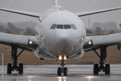 acercamiento a la nariz de un avion de pasajeros rodando en la pista de aterrizaje en un dia tormentoso