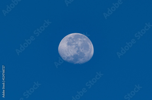 Full moon against blue sky background