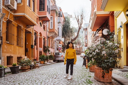 happy young girl exploring around kuzguncuk area with colorful building photo