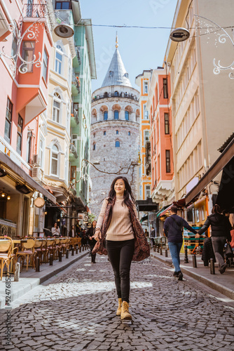 woman walking through an alley full with cafe and historical building in istanbul turkey © Odua Images