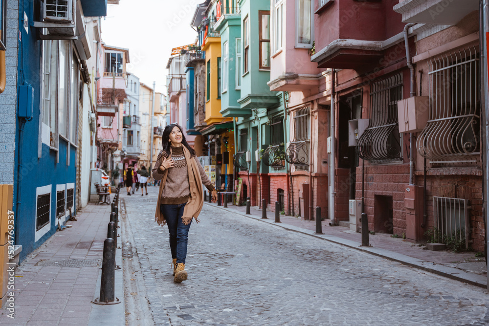 Fototapeta premium beautiful woman walking in balat turkey full of colorful house